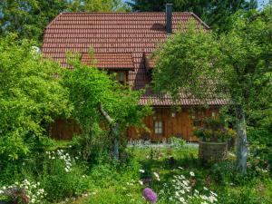 a house with a garden in front of it at Yeti Cabin in Plitvica Selo