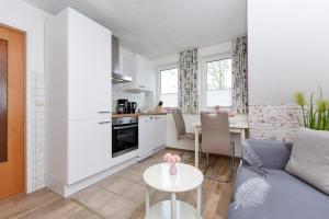 a kitchen and living room with a couch and a table at Haus am Kajedeich mit Frühstücksoption in Bensersiel