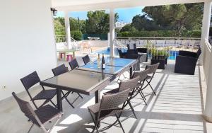 オーリョス・デ・アーグァにあるSunset Villa by Laranjal Rentalsのパティオ(テーブル、椅子付)、プールが備わります。