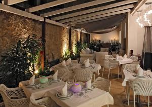 une salle à manger avec des tables et des chaises blanches dans l'établissement HOTEL PALM BEACH, à Cannes