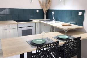 a kitchen with a wooden table with two green plates on it at Studio ,Centre Historique , Entrée Autonome in Montélimar