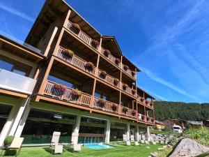 un edificio con balcones y plantas nutridas. en Francesin Active Hotel, en Livigno