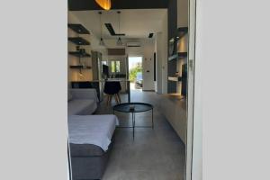 een woonkamer met een bank en een tafel bij Luxury 1 bedroom apartment in Ialysos in Ialyssos