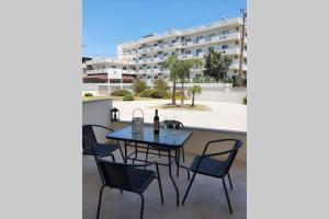 een tafel en stoelen op het balkon van een gebouw bij Luxury 1 bedroom apartment in Ialysos in Ialyssos