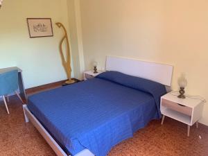 a bedroom with a blue bed and two night stands at B&B Murichessa(Il Gelso) in Orosei