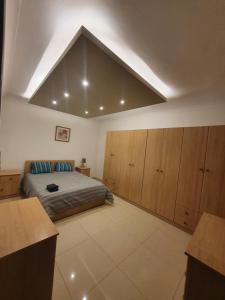 - une chambre avec un lit et des placards en bois dans l'établissement Savoy, à San Pawl il-Baħar