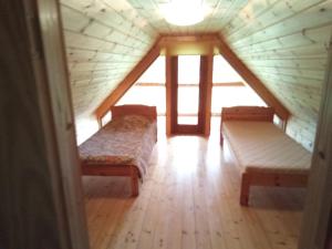a room with two beds in a log cabin at Rannamaa Holiday Home in Mändjala