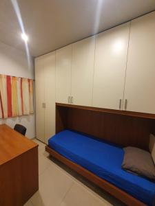 a bedroom with a blue bed and white cabinets at Savoy in St Paul's Bay +3 photos