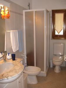 a white bathroom with a toilet and a sink at Gli Oleandri in Capoliveri +25 photos