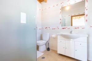 a white bathroom with a sink and a toilet at Villa Flavia in Aljezur