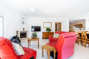 a living room with red furniture and a kitchen at Villa Flavia in Aljezur