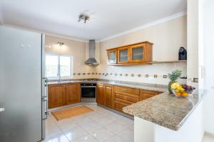 a kitchen with wooden cabinets and a counter top at Villa Flavia in Aljezur