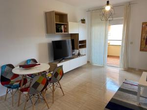 sala de estar con mesa, sillas y TV en Apartamento Adimar en San Luis de Sabinillas