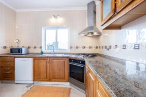 a kitchen with a sink and a stove at Villa Flavia in Aljezur