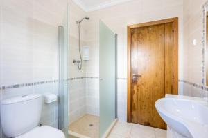 a bathroom with a toilet and a sink and a shower at Villa Flavia in Aljezur