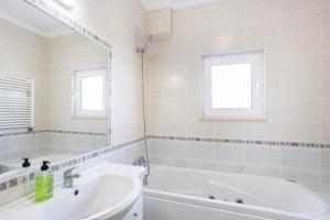 a white bathroom with a tub and a sink at Villa Flavia in Aljezur