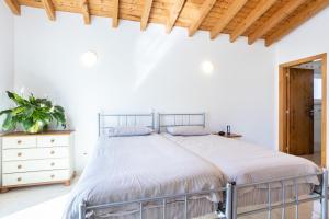 a white bedroom with a bed and a wooden ceiling at Villa Flavia in Aljezur