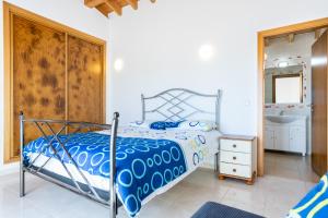 a bedroom with a bed with a blue comforter at Villa Flavia in Aljezur