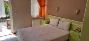 Habitación pequeña con cama y ventana en Tango Pension, en Koycegiz