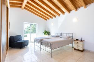 a bedroom with a bed and a chair at Villa Flavia in Aljezur