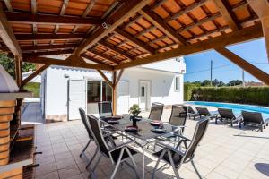 a patio with a table and chairs and a swimming pool at Villa Flavia in Aljezur