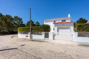 a white house with a fence and a driveway at Villa Flavia in Aljezur