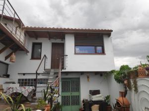een wit huis met een groene deur en een trap bij Apartamentos la Vega de Granada in Ambroz