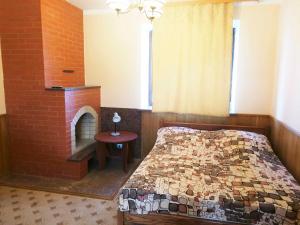 a bedroom with a bed and a brick fireplace at Dolinnaya Tower in Sudak