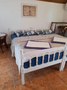 a bedroom with a white bed with blue pillows at Ana & Stela in Karlobag