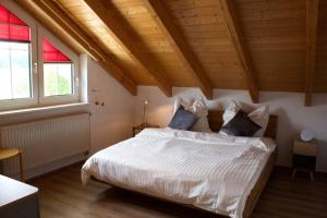 a bedroom with a white bed with two windows at Kuschelige Ferienwohnung mit Balkon & Free Wifi in Buchenberg