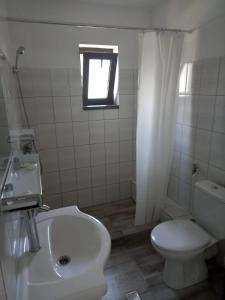 a bathroom with a sink and a toilet and a window at CASA SMARALD in Costinesti
