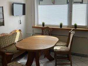 a wooden table and chairs in a room with windows at Sauerland-Relax in Schmallenberg