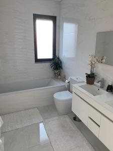 
a bathroom with a tub, toilet and sink at Casa da Colina - Villa in the Countryside in Sobral do Parelhão
