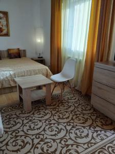 アドレルにあるAlexandra Guest Houseのベッドルーム1室(ベッド1台、椅子、テーブル付)