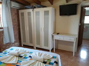 a bedroom with a bed and a desk and a tv at Estudio Cala Saona in Cala Saona