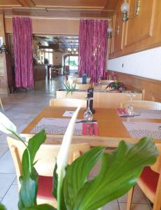 restauracja ze stołami, krzesłami i różowymi zasłonami w obiekcie Hôtel Lion d'Or Romont w mieście Romont