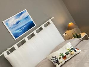 1 Schlafzimmer mit einem weißen Bett mit einem weißen Kopfteil in der Unterkunft HOME CITY in Castellammare del Golfo