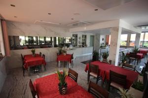 un restaurant avec des tables et des chaises rouges et un comptoir dans l'établissement Pension Silvia, à Portorož