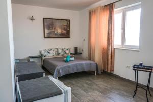 a small bedroom with a bed and a window at Vila Gladiola in Eforie Nord