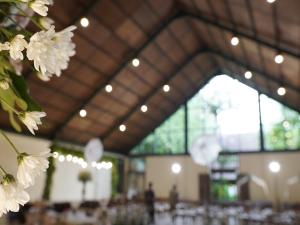 ein Zimmer mit Tischen und weißen Blumen darin in der Unterkunft Imah Seniman in Lembang + 47 Fotos