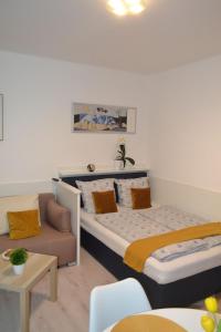 two beds in a room with a couch and a table at Arapartman in Zamárdi