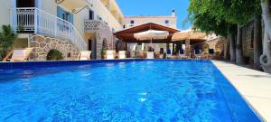 a large blue swimming pool next to a building at Kastro Hotel in Spetses