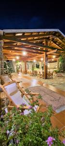 pawilon ze stołami, krzesłami i kwiatami w budynku w obiekcie Kastro Hotel w mieście Spetses