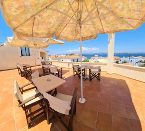 a patio with a table and chairs and an umbrella at Kastro Hotel in Spetses