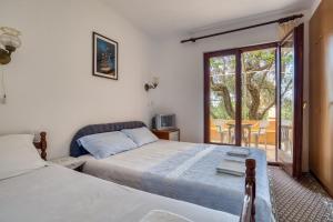 1 dormitorio con 2 camas y balcón en Guest House Vukovic, en Petrovac na Moru