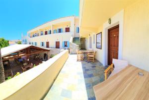 a balcony of a building with a table and chairs at Kastro Hotel in Spetses