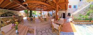 a restaurant with tables and chairs and a pool at Kastro Hotel in Spetses