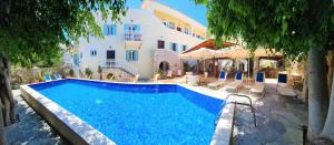 a swimming pool in front of a building at Kastro Hotel in Spetses