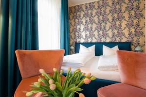 a hotel room with a bed and two chairs at Waldidylle Gohrisch, Pension und Ferienwohnungen in Kurort Gohrisch