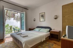 a bedroom with a bed and a tv and a window at Guest House Vukovic in Petrovac na Moru +34 photos